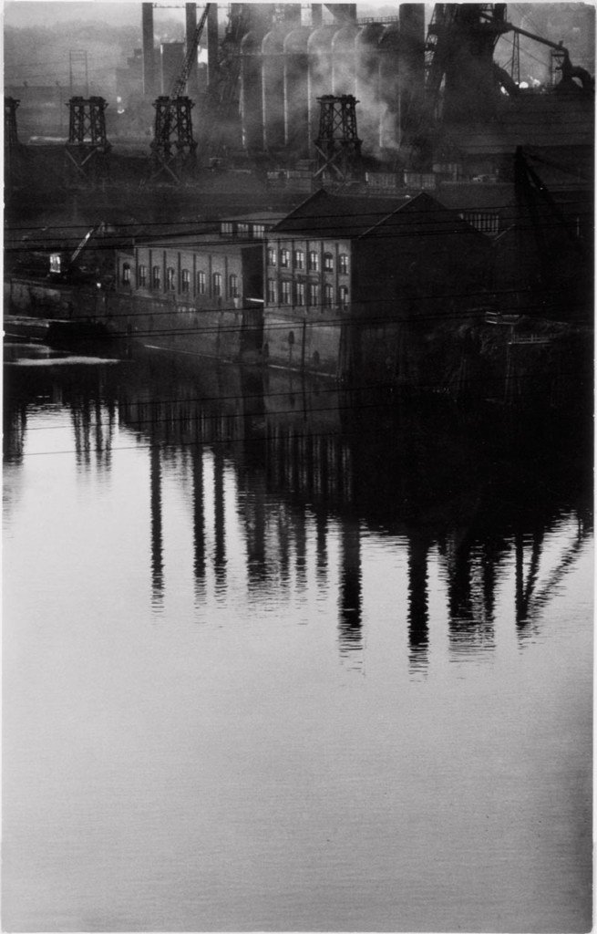 MAST: fotografia di Eugene Smith. Città industriale riflessa sull'acqua